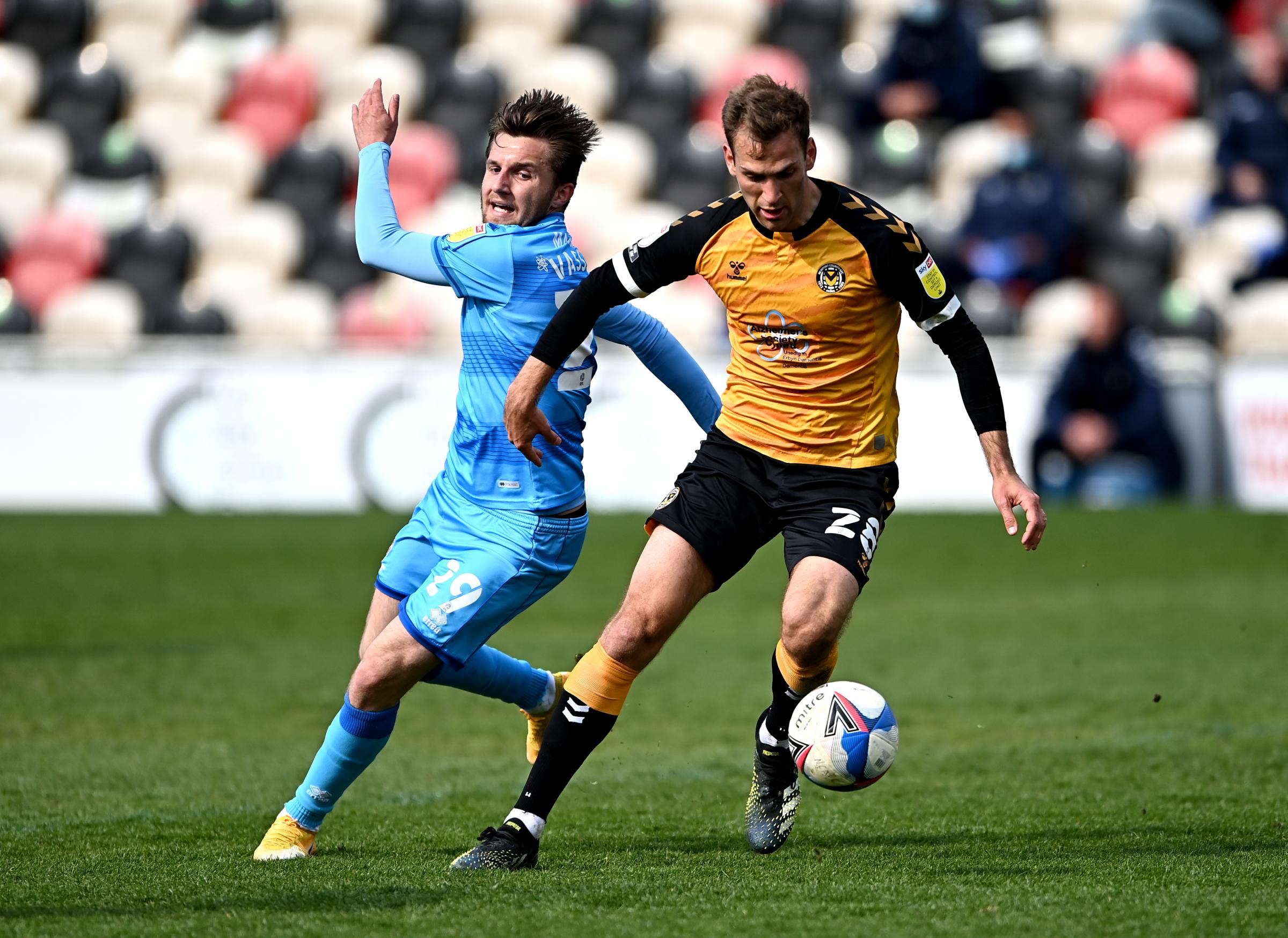 Newport Countys Mickey Demetriou (right) and Cheltenham Towns Indiana Vassilev battle for the ball during the Sky Bet League Two match at Rodney Parade, Newport. Issue date: Saturday May 1, 2021.