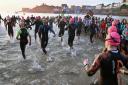 The shoal of Ironman Wales swimmers enter the water at sunrise today. Picture: Gareth Davies Photography