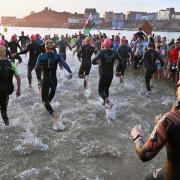 The shoal of Ironman Wales swimmers enter the water at sunrise today. Picture: Gareth Davies Photography